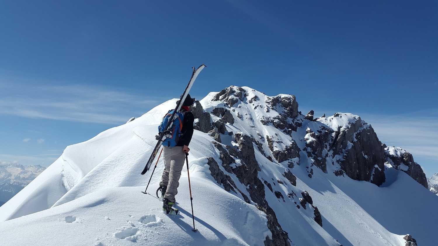 Mężczyzna z nartami w górach